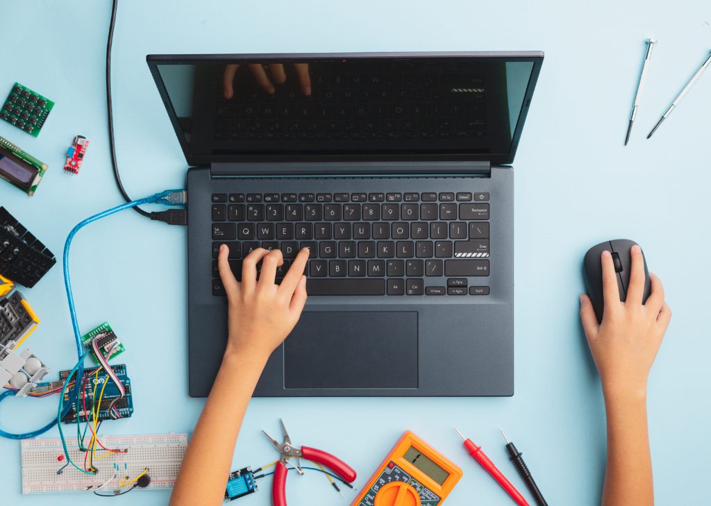 Tangan anak kecil berada di depan laptop atau komputer