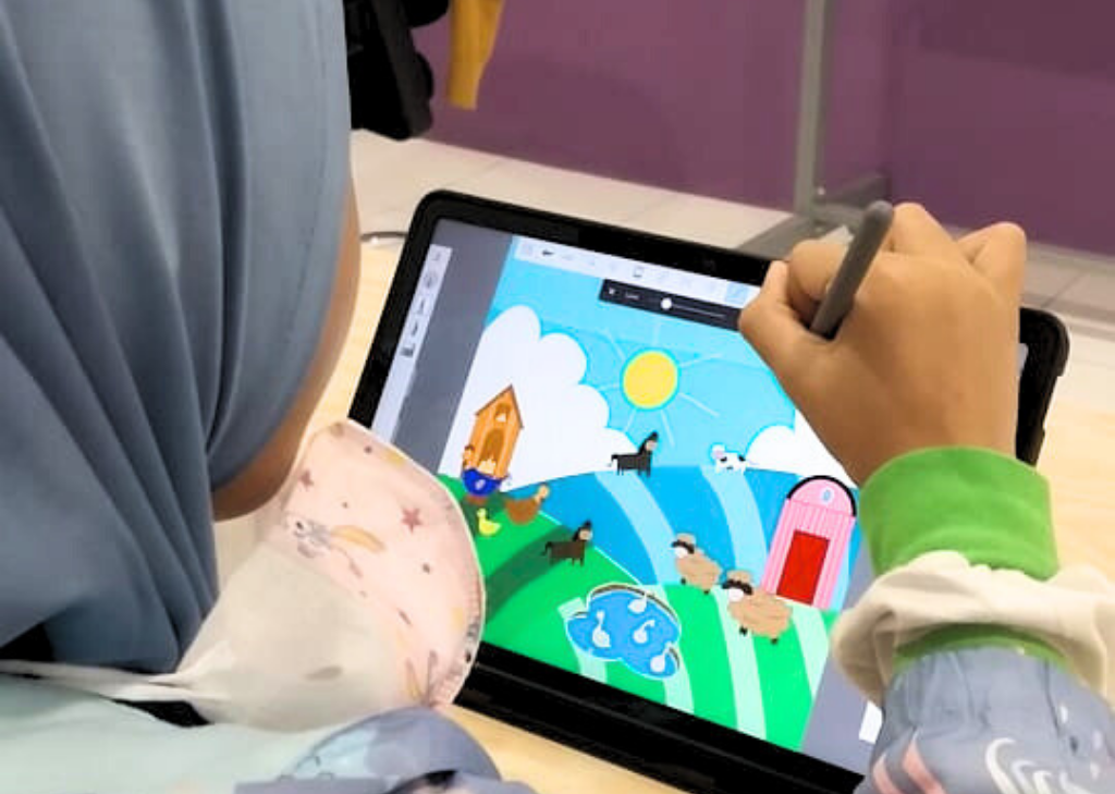 Anak perempuan menggambar menggunakan tab
